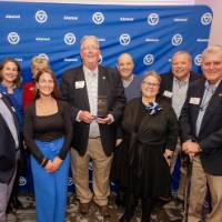 Bob Stoll smiles with his award surrounded by supporters